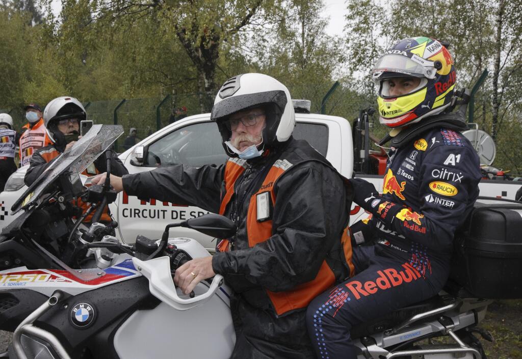 WA 41 Spa - Mexického pilota F1 Sergia Pereza (vpravo) z Red Bullu odvážajú na motorke po tom, čo narazil do bariéry pred štartom Veľkej ceny Belgicka automobilov F1 na okruhu Spa-Francorchamps v nedeľu 29. augusta 2021. FOTO TASR/AP
Red Bull driver Sergio Perez of Mexico, right, gets on the back of a motorbike to return to the garage after crashing his car on his way to the grid during the Formula One Grand Prix at the Spa-Francorchamps racetrack in Spa, Belgium, Sunday, Aug. 29, 2021. (AP