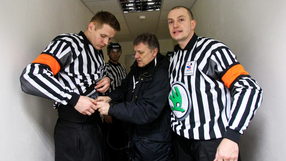 Na snimke technik RTVS montuje mikrofon hlavnym rozhodcom Jozefovi Kubusovi a Vladimirovi Baluskovi pocas prveho zapasu medzinarodneho hokejoveho turnaja SLOVAKIA CUP 2015.
