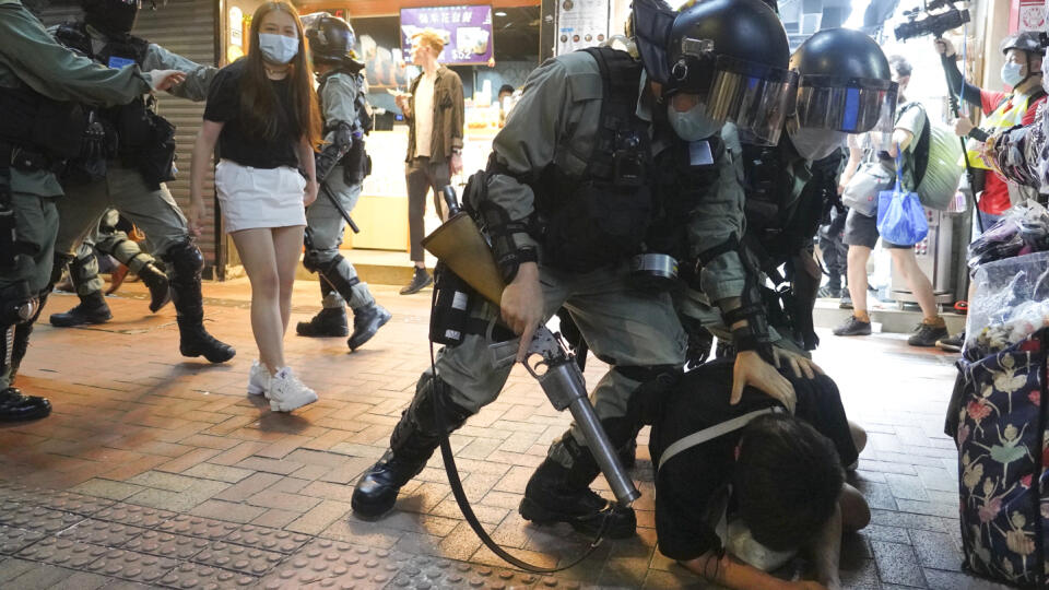 Príslušníci hongkongských poriadkových síl zatýkajú demonštranta počas protestu na Causeway Bay v Hongkongu 12. júna 2020.