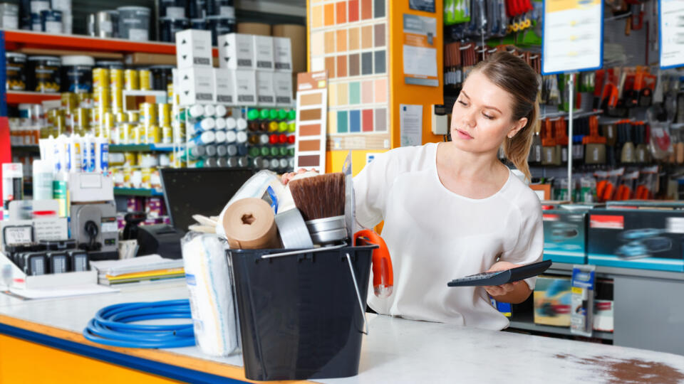 Young,Pleasant,Female,Seller,Standing,At,The,Counter,In,Household