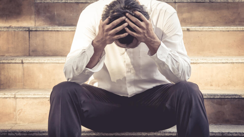 Stressed,Business,Man,Sitting,With,Hand,On,Head