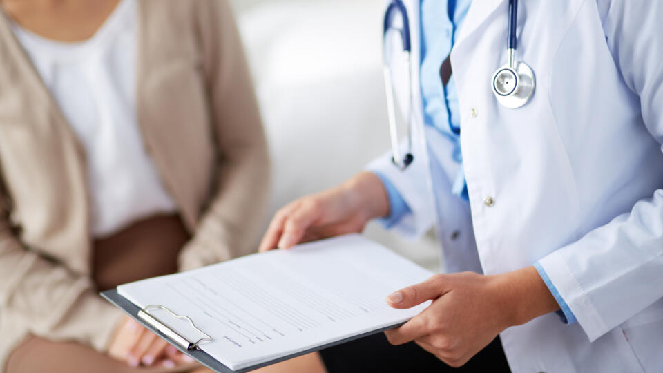 Female,Doctor,Holding,Application,Form,While,Consulting,Patient