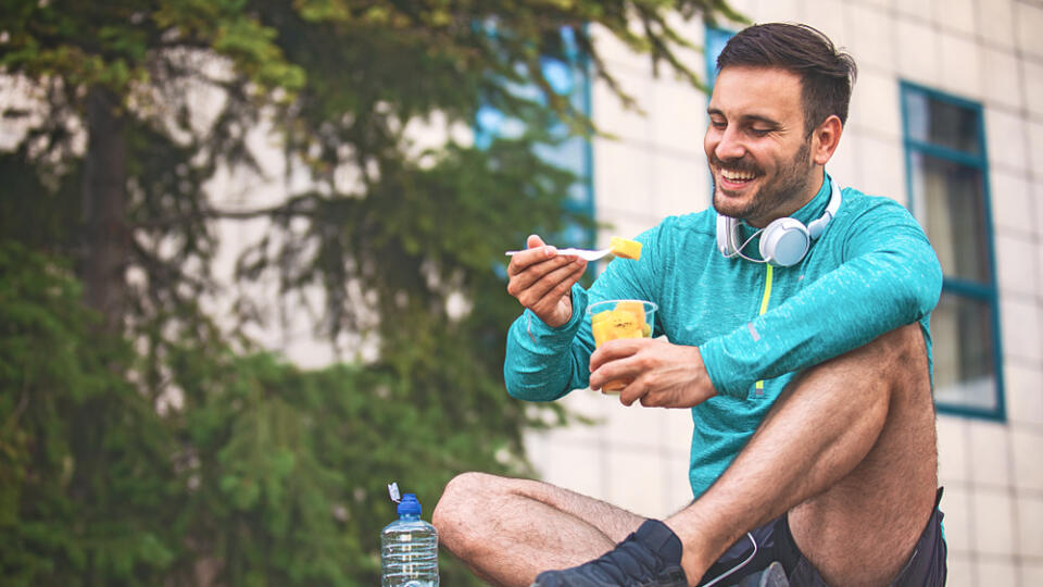 Young,Athlete,Man,Eating,Fruit,After,Exercising.