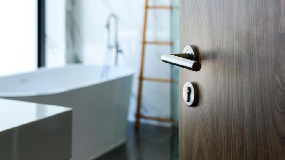 Wooden,Door,Open,To,Nice,Modern,Bathroom,,Marble,Walls.,Selective