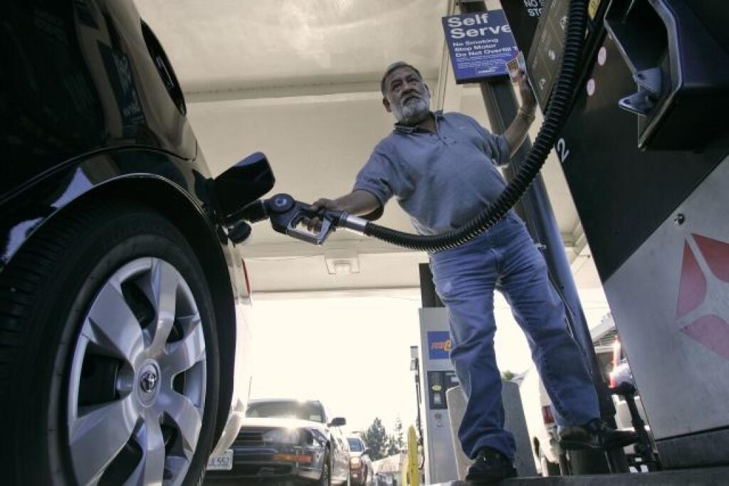 ** FILE ** In this Nov. 21, 2007, file photo, Santiago Santos fuels up his car at a gas station in San Jose, Calif. Oil prices headed slightly lower Monday, Dec. 31, 2007, marking a quiet end to a record-breaking year, although rising demand and geopolitical instability are expected to keep upward pressure on energy costs early in 2008. (AP Photo/Marcio Jose Sanchez, File)