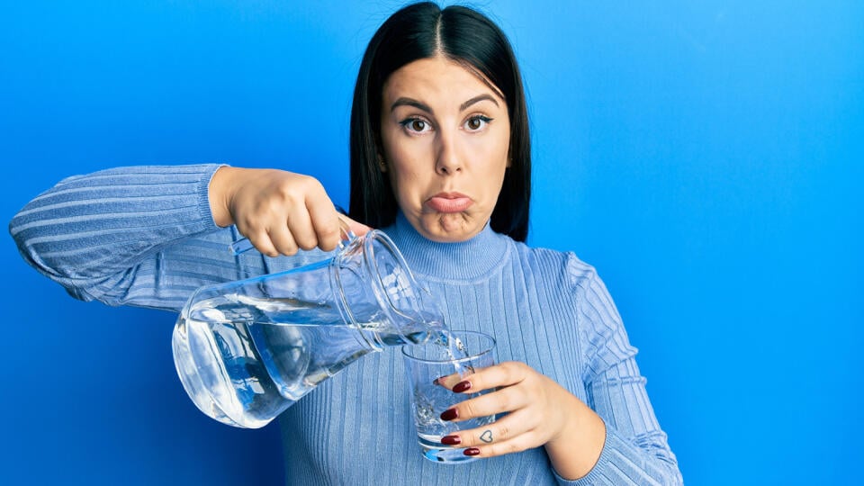 Beautiful,Brunette,Woman,Pouring,Water,In,Glass,Depressed,And,Worry