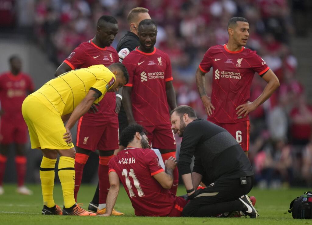 Zranený futbalista Liverpoolu Mohamed Salah sedí na trávniku počas finálového zápasu Pohára FA Chelsea Londýn - FC Liverpool v Londýne v sobotu 14. mája 2022.