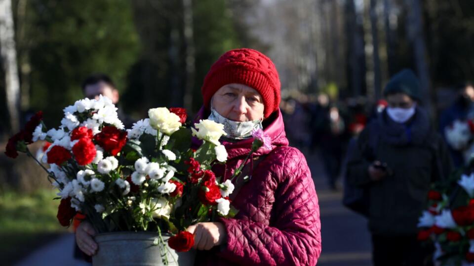 People carry flowers to pay their respects to Roman Bondarenko, an anti-government protester who died in hospital following what witnesses said was a severe beating by security forces, during a funeral ceremony in Minsk, Belarus