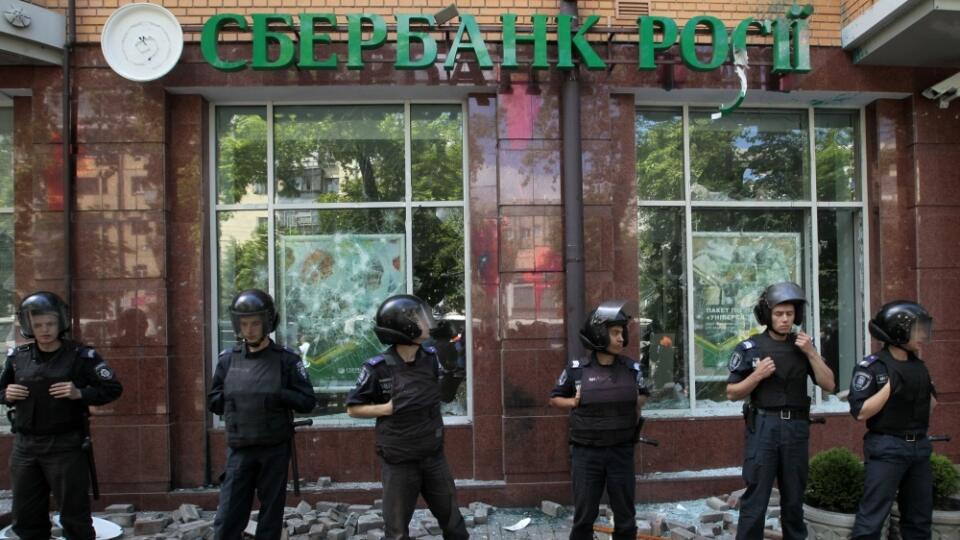 Riot police protect the office of the Russian Sberbank after radical groups of people attacked it with the stones in Kiev, Ukraine, Sunday, June 22, 2014. (AP Photo/Sergei Chuzavkov)