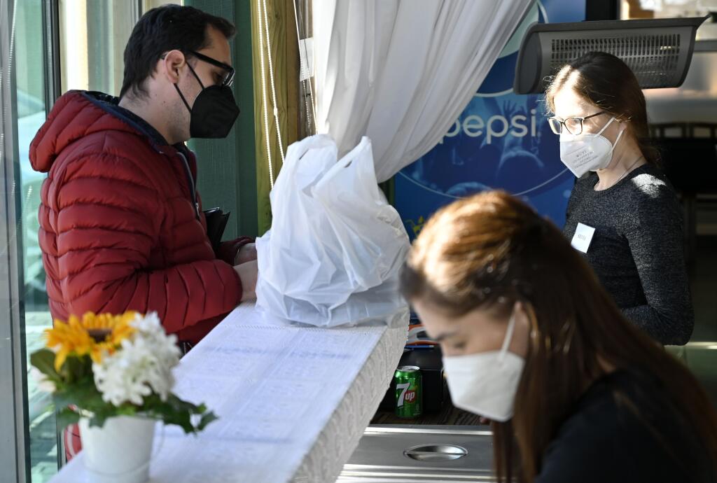 Regionálny úrad verejného zdravotníctva (RÚVZ) so sídlom v Michalovciach eviduje roztrúsený výskyt ochorenia COVID-19 po celom okrese. Okres Michalovce prešiel od pondelka na základe COVID automatu z bordovej do čiernej fázy, ktorá zodpovedá tretiemu stupňu ohrozenia. Na snímke výdaj balených obedov z okienka v reštaurácii v Michalovciach v pondelok 25. októbra 2021. FOTO TASR - Roman Hanc