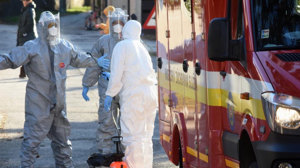 Na snímke hasičov dezinfikujú po mobilnom odbere vzoriek pacienta podozrivého na ochorenie na koronavírus v jednej z bratislavských štvrtí. B