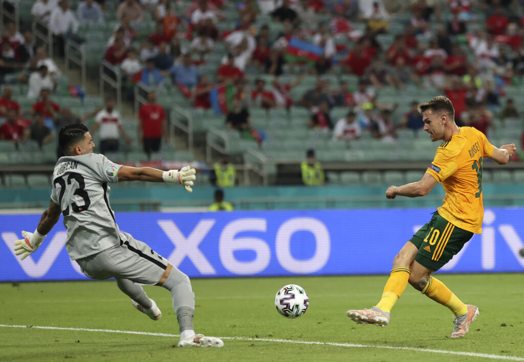 EBE 27 Baku - Na snímke vpravo waleský stredopoliar Aaron Ramsey strieľa úvodný gól v zápase A-skupiny na majstrovstvách Európy vo futbale Turecko – Wales v stredu 16. júna 2021 v azerbajdžanskom Baku. FOTO TASR/AP
Wales' Aaron Ramsey, right, scores his sides first goal past Turkey's goalkeeper Ugurcan Cakir during the Euro 2020 soccer championship group A match between Turkey and Wales the Baku Olympic Stadium in Baku, Azerbaijan, Wednesday, June 16, 2021. (Naomi Baker/Pool via AP)