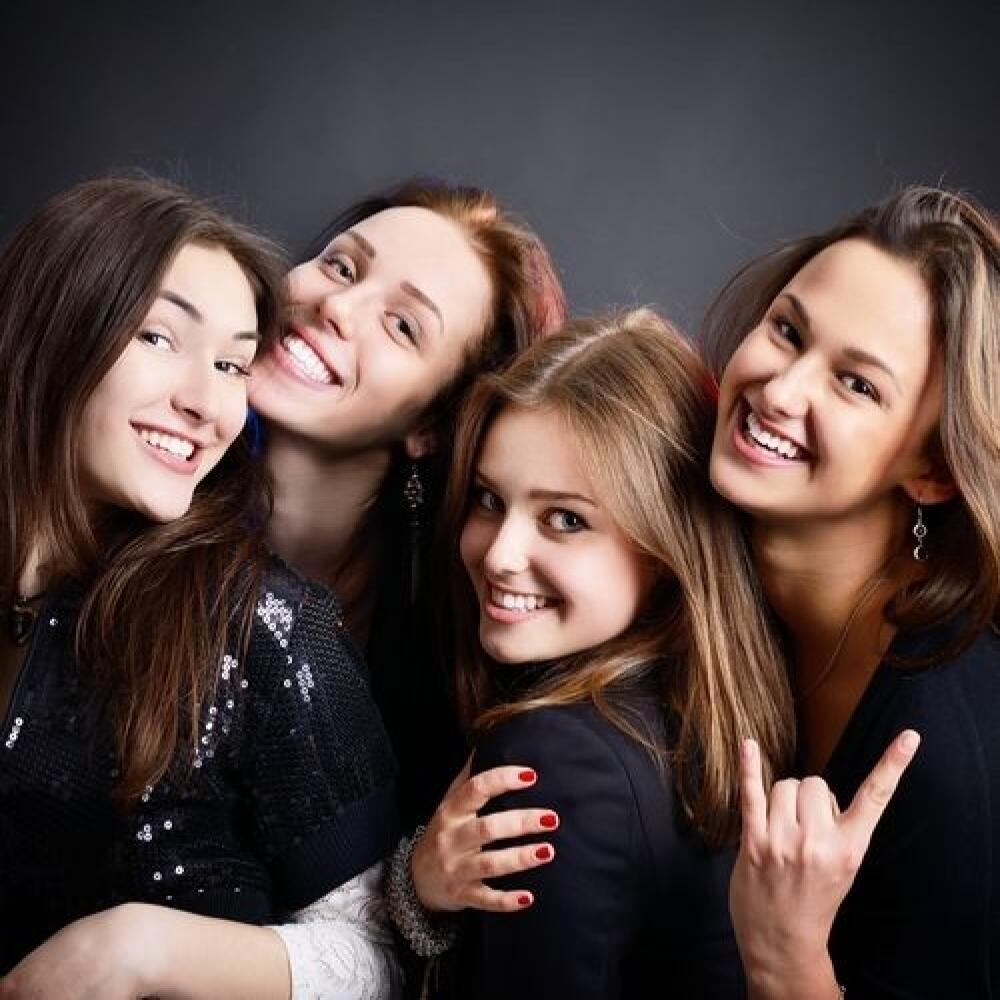 fashionable attractive happy party teen girls smiling over black background