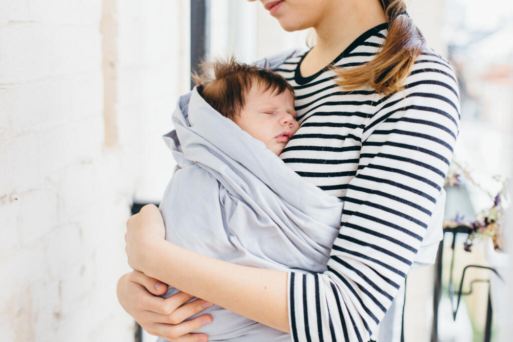 Mother,Carrying,Her,Baby,In,A,Sling,Outdoors