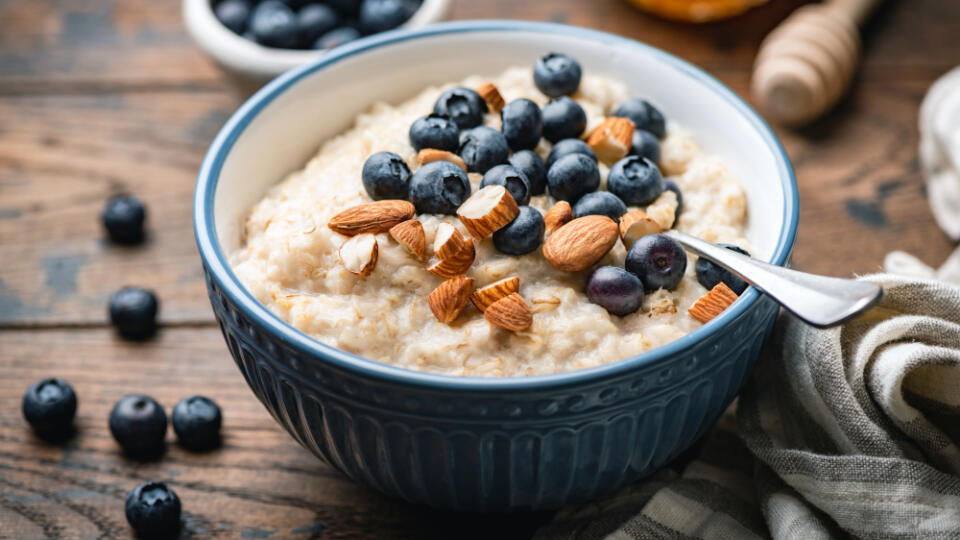 Oatmeal,Porridge,With,Blueberries,,Almonds,In,Bowl,On,Wooden,Table