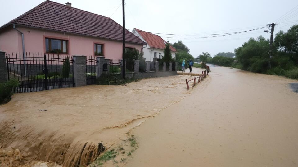 Povodňová situácia v obci Zvolenská Slatina v okrese Zvolen. Prívalové dažde narobili v obci problémy. Na snímke vybrežený potok Očovka zaplavil cestu a domy vo Zvolenskej Slatine 14. júna 2020. FOTO TASR - Ján Krošlák