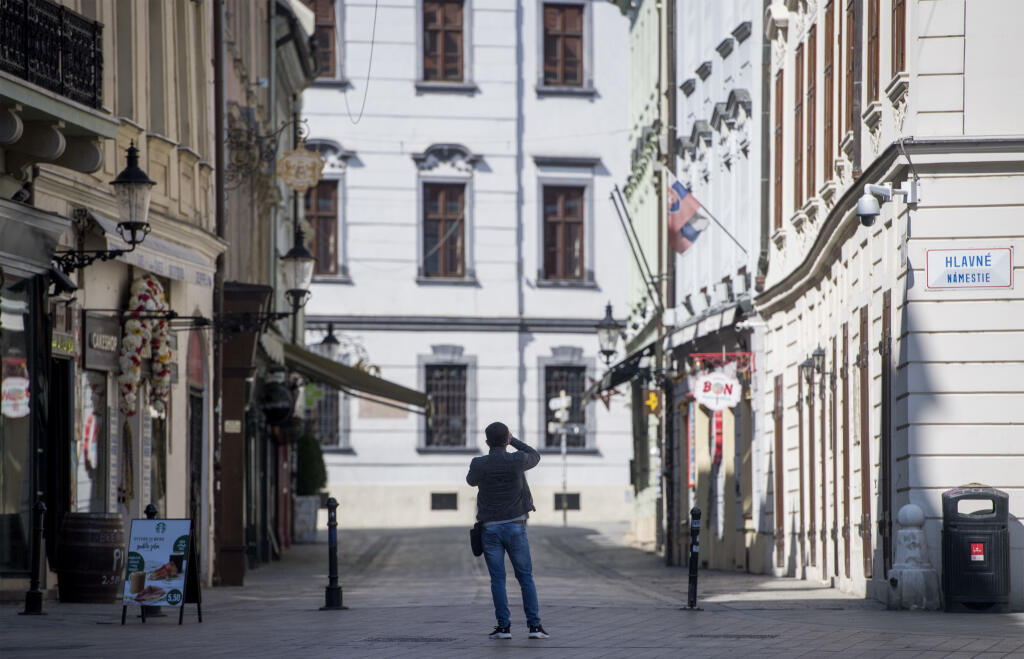 Na snímke muž si fotí na Hlavnom námestí prázdne centrum Bratislavy počas koronavírusovej pandémie v sobotu 4. apríla 2020. FOTO TASR - Martin Baumann