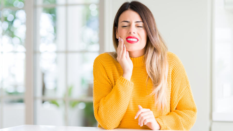 Young,Beautiful,Woman,Wearing,Winter,Sweater,At,Home,Touching,Mouth