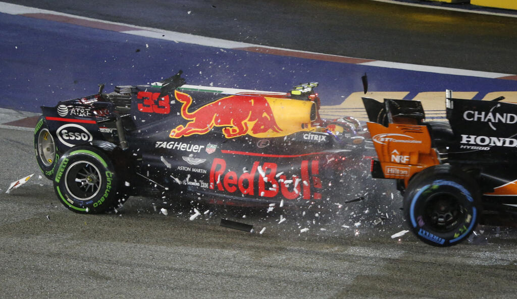 Ferrari driver Kimi Raikkonen of Finland collides with Red Bull driver Max Verstappen of the Netherlands and McLaren driver Fernando Alonso, right, of Spain at the start of the Singapore Formula One Grand Prix on the Marina Bay City Circuit Singapore, Sunday, Sept. 17, 2017. (AP Photo/Yong Teck Lim)