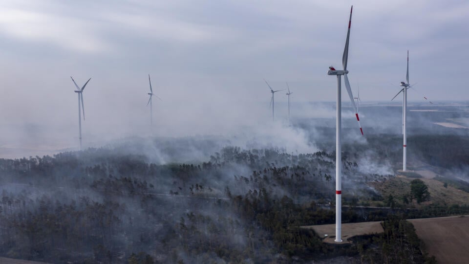 KK14 Falkenberg - Oblaky dymu sa vznášajú nad lesnou oblasťou počas lesného požiaru medzi veternými turbínami v skorých ranných hodinách neďaleko nemeckého Falkenbergu v utorok 26. júla 2022. Na východe Nemecka vypukol v pondelok rozsiahly lesný požiar, ktorý si vyžiadal evakuácie a ohrozil aj fungovanie viacerých veterných turbín v oblasti. FOTO TASR/AP
Clouds of smoke drift over a forest area during a forest fire between wind turbines in the early morning near Falkenberg, Germany, Tuesday, Jul