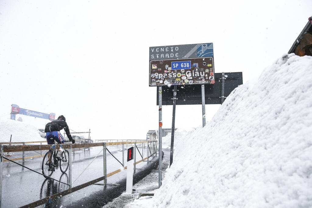 Osamotený cyklista prechádza počas sneženia cez horský priesmyk Giau v Dolomitoch počas 16. etapy cyklistických pretekov Giro d'Italia