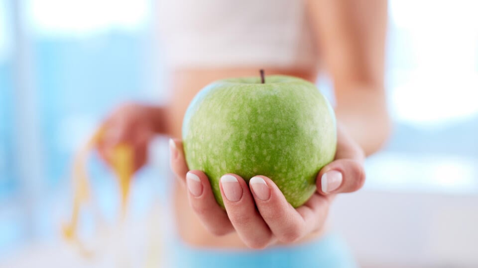 Close-up,Of,A,Fit,Woman,Holding,A,Fresh,Apple