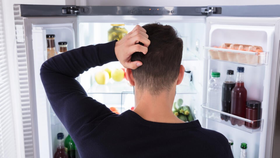 Rear,View,Of,A,Confused,Young,Man,Looking,At,Food