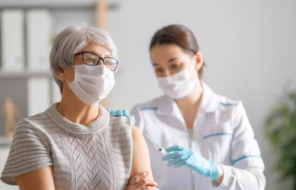 Doctor,Giving,A,Senior,Woman,A,Vaccination.,Virus,Protection.,Covid-2019.