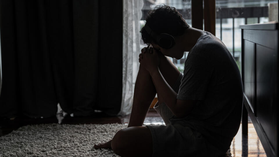 Wide,Shot,Young,Adult,Asian,Loneliness,Sad,Man,Sitting,On