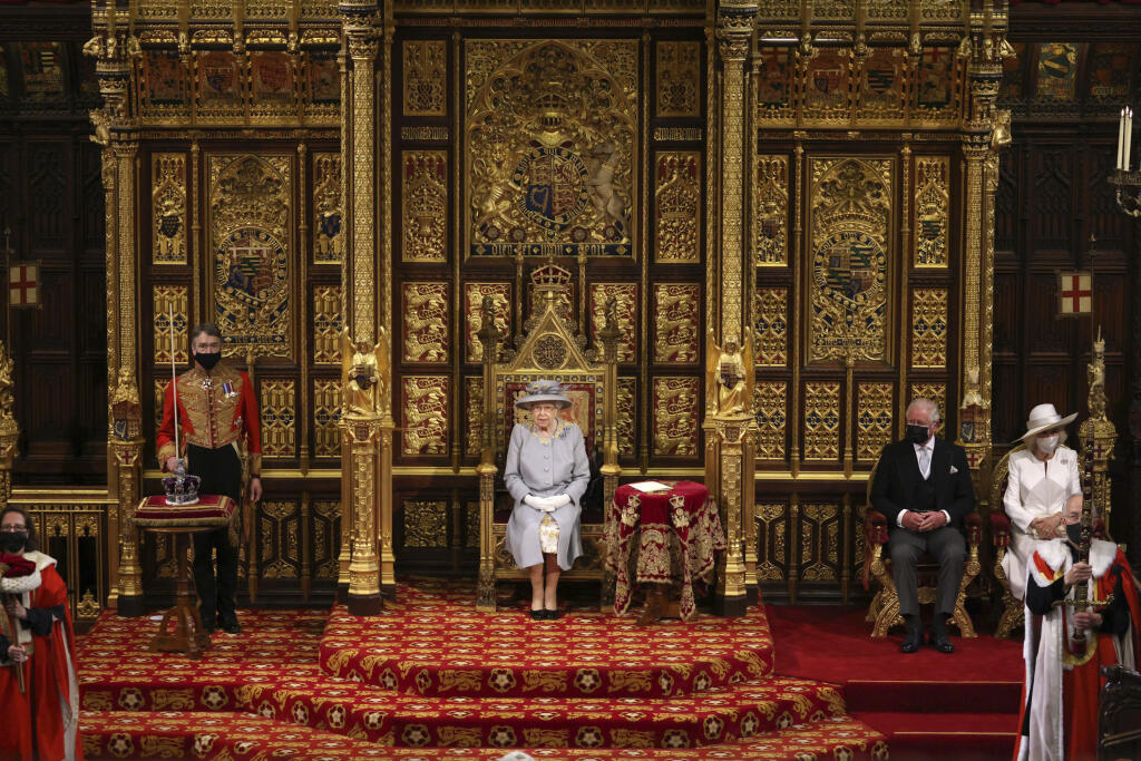 Na snímke uprostred britská kráľovná Alžbeta II., druhý sprava korunný princ Charles a vpravo jeho manželka Camilla počas slávnostného otvorenia schôdze britského parlamentu v Londýne 11. mája 2021.