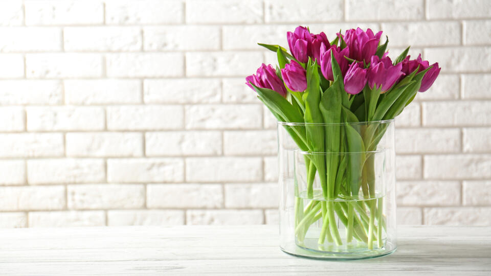 Glass,Vase,With,Bouquet,Of,Beautiful,Tulips,On,Brick,Wall