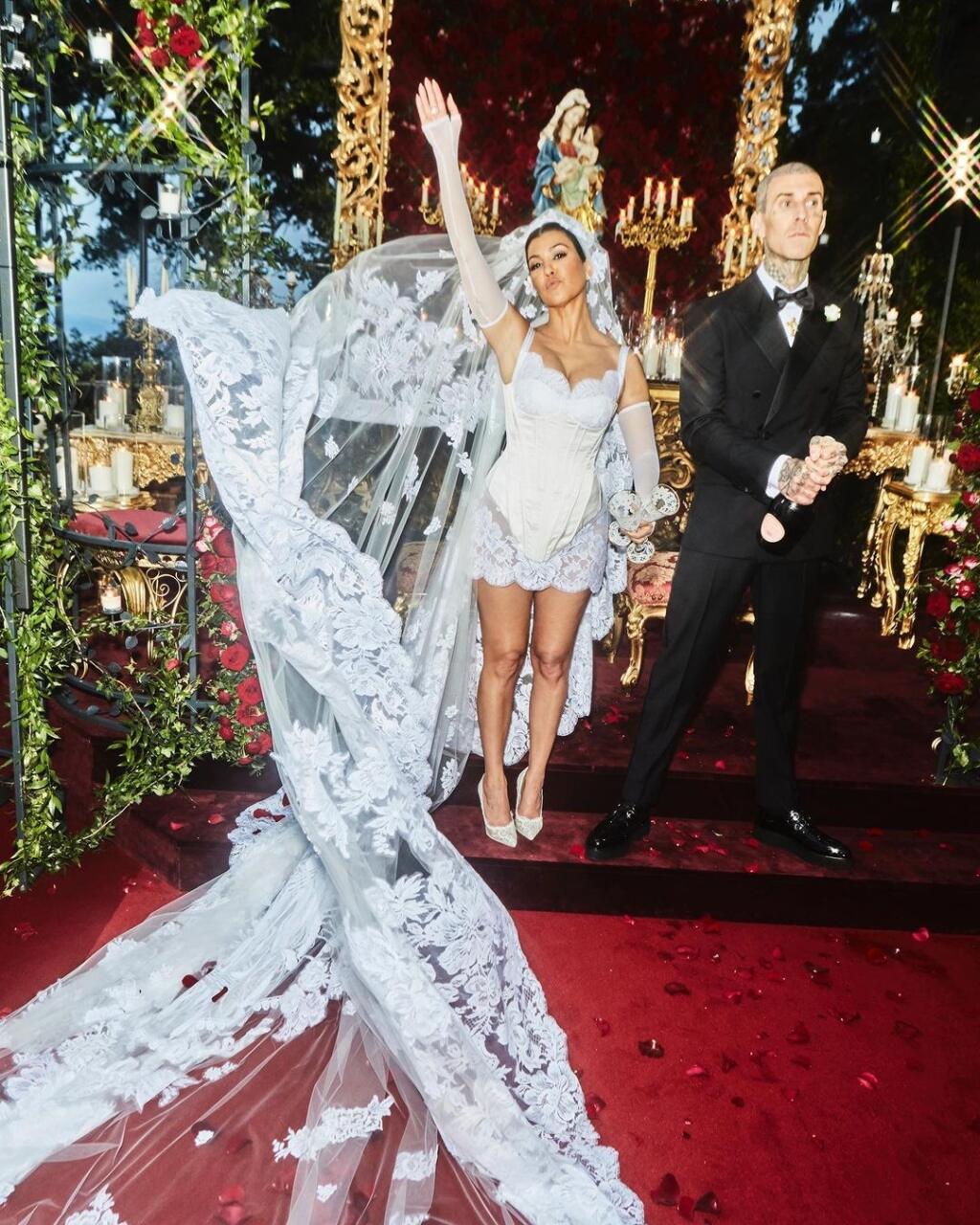 Kourtney Kardashian a Travis Barker absolvovali hneď niekoľko medzinárodných svadobných osláv, vrátane nočnej výmeny sľubu vo Vegas. Nič sa však nevyrovná svadobným šatám, ktoré mala Kourtney na sebe v talianskom Portofine. Niekoľkodňový svadobný víkend hostila spoločnosť Dolce & Gabbana a talianska módna značka navrhla aj jej dnes už slávne svadobné šaty : jedinečné saténové mini s jemnulinkou čipkou. Najvýraznejším doplnkom bol však závoj a čelenka, ktorá obsahovala veľké zobrazenie Panny Márie.
