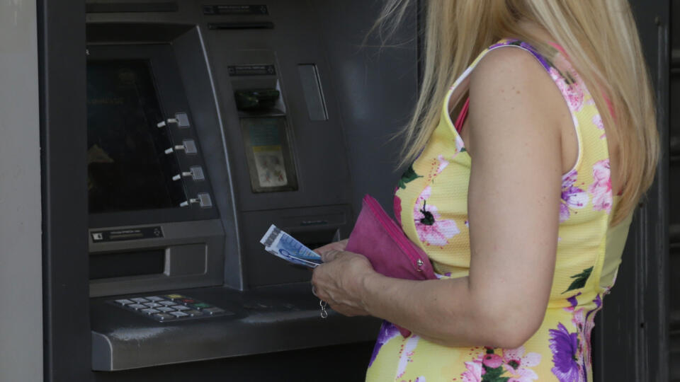 Žena si vyberá hotovosť z bankomatu