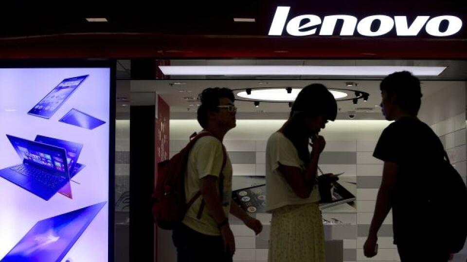People walk past a Lenovo flagship experience store in Beijing, China Thursday, Aug. 15, 2013. Lenovo Group says it is evolving quickly into a supplier of wireless computing, driven by booming sales of smartphones and tablets as consumers shift away from desktop computers. (AP Photo/Andy Wong)