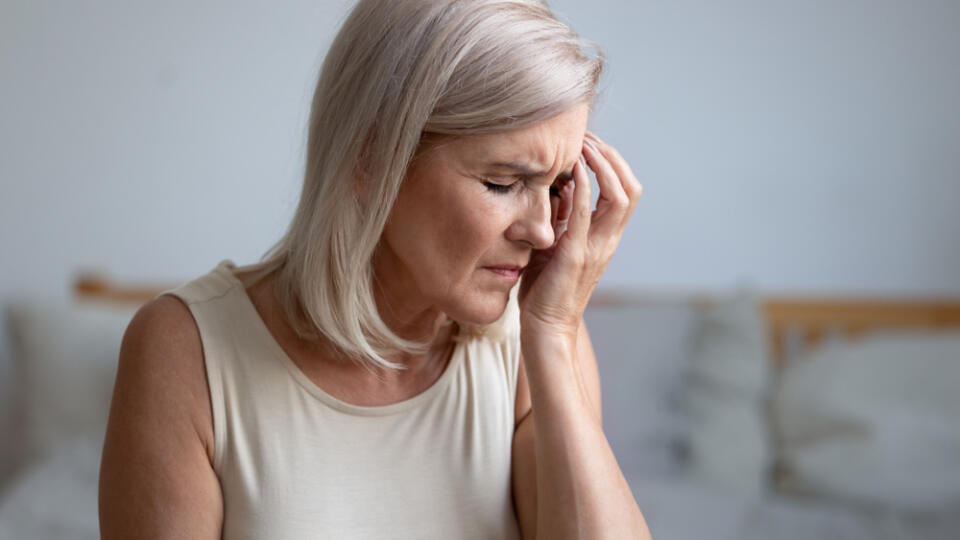 Close,Up,Of,Tired,Middle-aged,Woman,Touches,Face,With,Hand