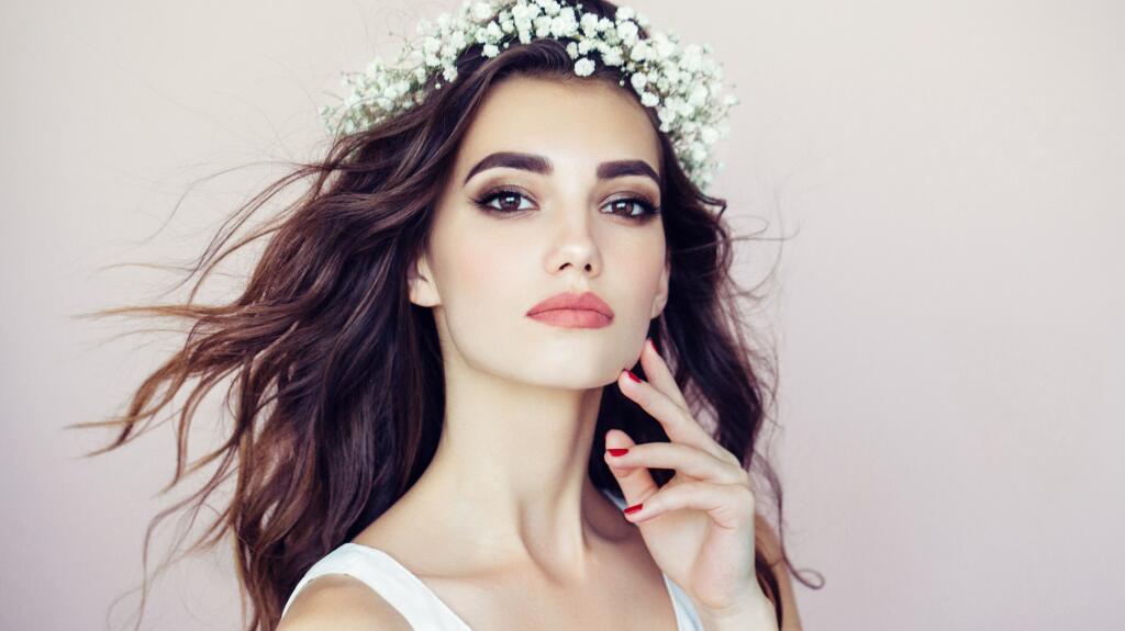 Studio shot of young beautiful woman on light background. Professional make-up and hairstyle.