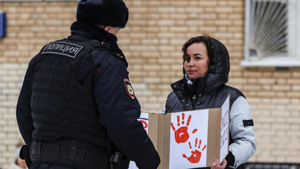 Policajt zadržiava ženu s plagátom pri soche ukrajinskej spisovateľky Lesii Ukrajinky počas prvého výročia ruskej agresie na Ukrajinu 24. februára 2023 v Moskve.