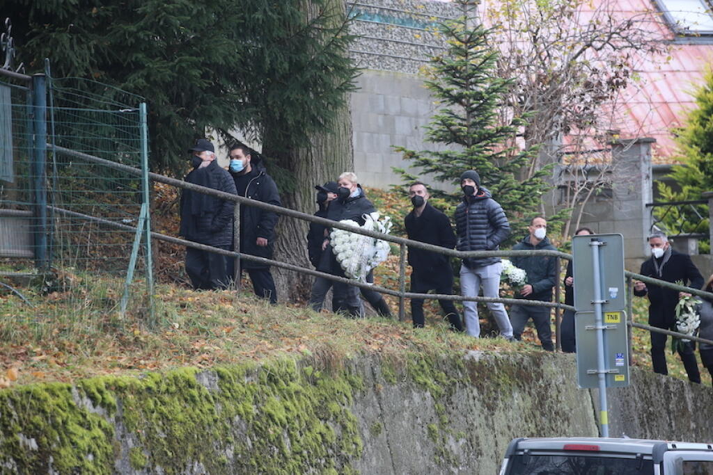 Smútiaci hostia pomaly kráčali za truhlou, ktorú tlačili páni v klobúkoch.