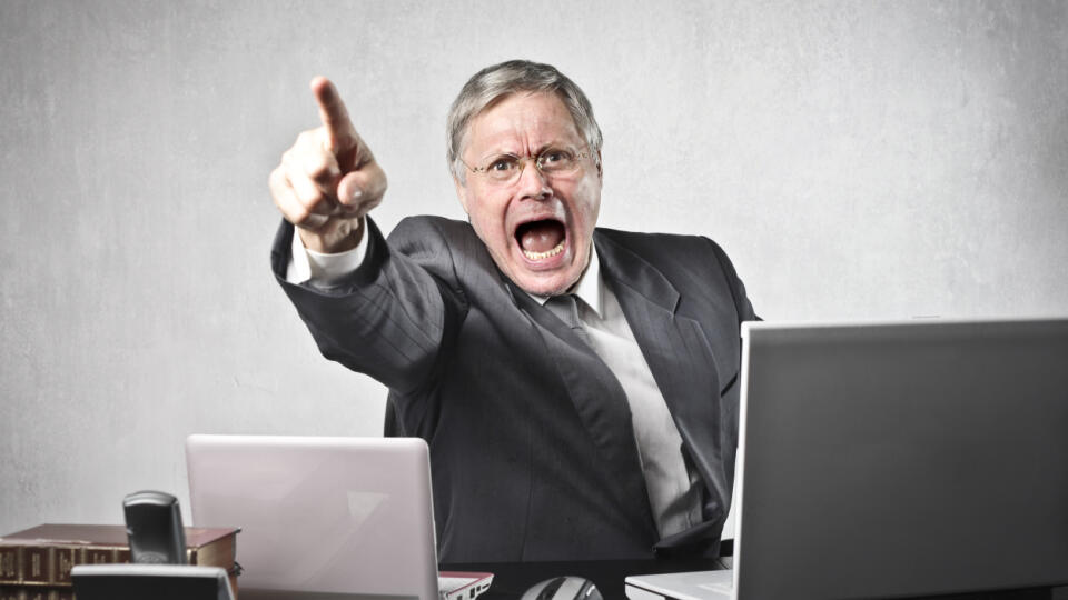 Angry,Senior,Businessman,Sitting,At,His,Desk,And,Screaming