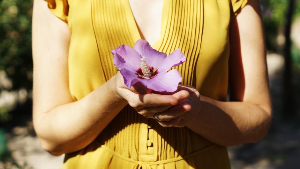 A,Woman,In,A,Yellow,Dress,Holding,A,Fresh,Purple