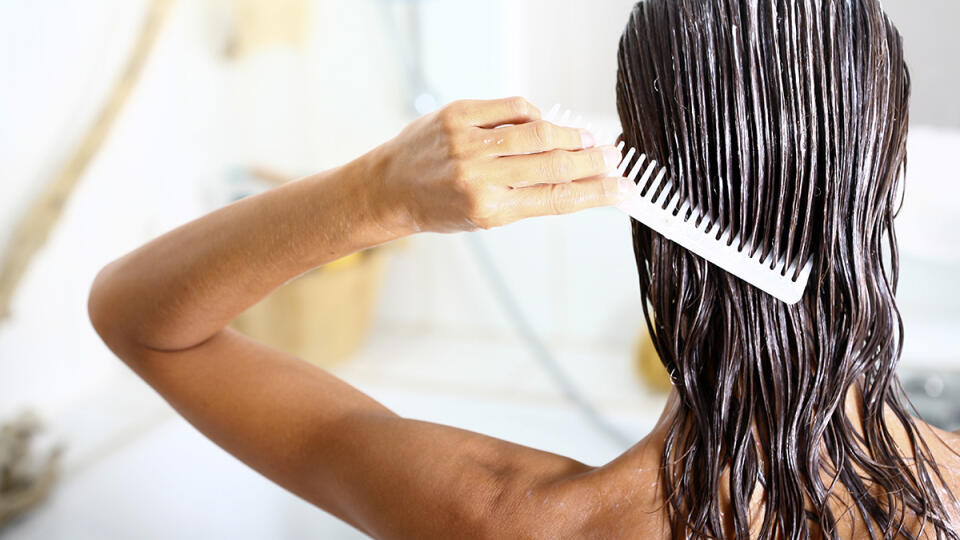 Woman,Applying,Hair,Care,With,A,Comb