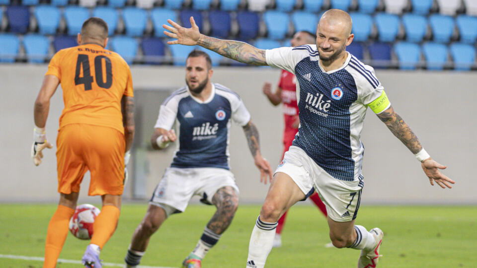 Na snímke vpravo hráč Slovana Vladimír Weiss ml. sa raduje z gólu z druhej penalty, uprostred spoluhráč Tigran Barseghjan a vľavo brankár luxemburského FC Swift Hesper Geordan Dupire v odvetnom zápase 1. predkola Ligy majstrov FC Swift Hesper - ŠK Slovan Bratislava v Luxemburgu v stredu 19. júla 2023. FOTO TASR - Martin Baumann