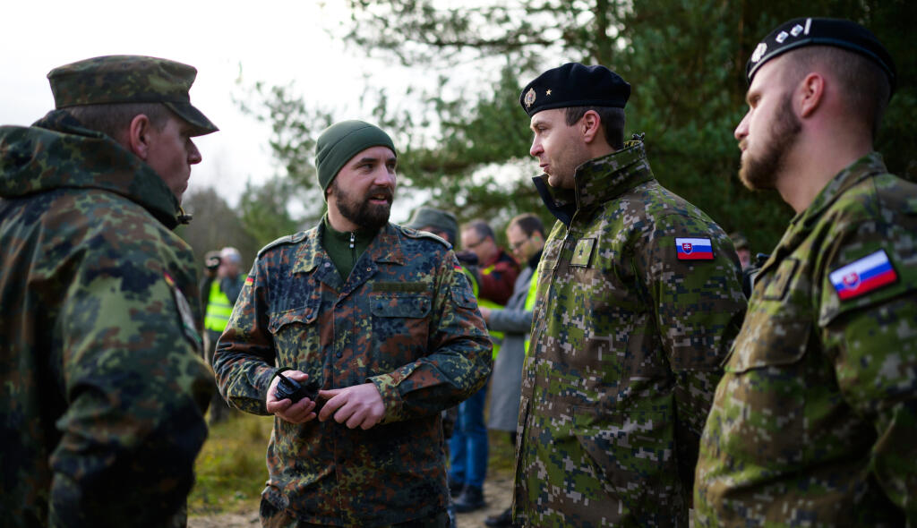 JB 8 Münster - Vojaci a inštruktori nemeckého  Bundeswehru sa rozprávajú so slovenskými vojakmi v rámci prestávky počas vojenského cvičenia na riadenie bojového tanku Bundeswehru Leopard 2 A4 vo výcvikovom stredisku v nemeckom meste Münster 24. novembra 2022. Nemecký Bundeswehr momentálne dáva výcvik slovenským vojenským vodičom na bojovom tanku typu Leopard 2 A4. Nemecká zbrojárska spoločnosť Rheinmetall dodá Slovensku v decembri tohto roka prvý z celkovo 15 tankov Leopard. FOTO TASR/DPA

24.11