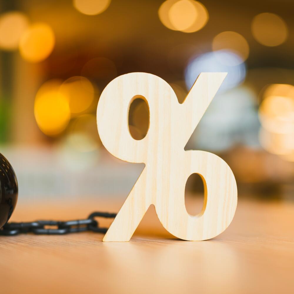 Percentage symbol planted with prison pendulum as image with concept of credit bureau debt detection and debt repayment planning, house and car refinancing, debt check.