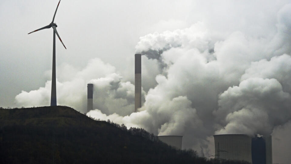 A wind turbine overlooks the E.ON coal-fired power station in Gelsenkirchen, Germany, Monday, Dec. 1, 2014. Sweeping change in the electricity business and the rise of renewable energy are behind German utility E.ON's decision to spin off its conventional power plants — and create two companies that can each focus on what it does best. E.ON CEO Johannes Teyssen said Monday that conventional power generation will remain indispensable but that a