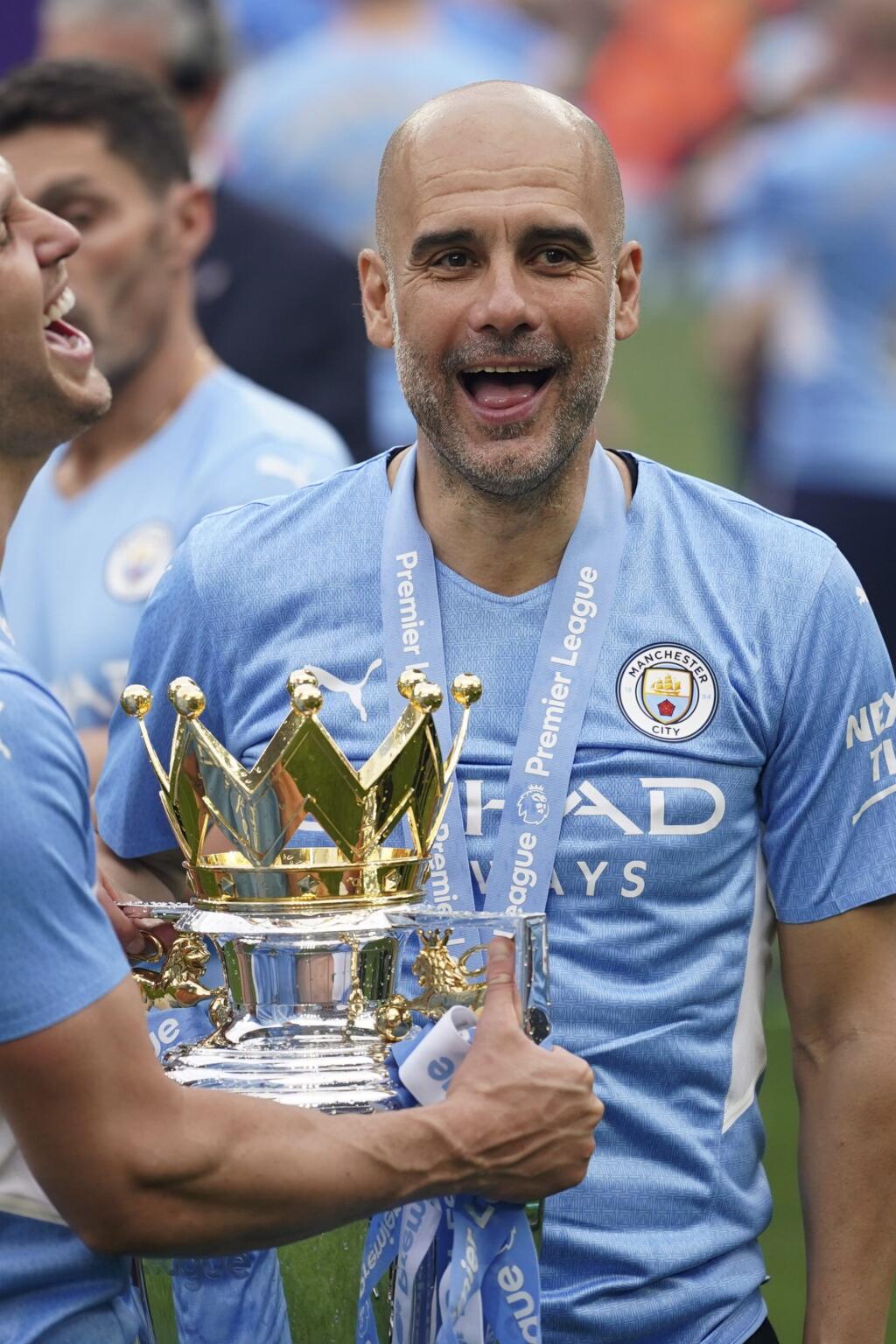PK 90 Manchester - Tréner Manchestru City Pep Guardiola sa teší s trofejou po triumfe v anglickej Premier League po zápase záverečného 38. kola anglickej Premier League Manchester City - Aston Villa v Manchestri v nedeľu 22. mája 2022. Futbalisti Manchestru City zdolali doma Aston Villu 3:2 a obhájili titul v najvyššej anglickej súťaži. FOTO TASR/AP
Manchester City's head coach Pep Guardiola, right, smiles with trophy after winning the 2022 English Premier League title at the Etihad Stadium in