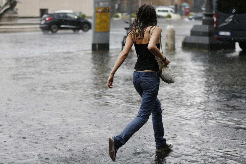 WA 37 Rím - Žena beží počas búrky a silnom daždi v centre Ríme v utorok 8. júna 2021. FOTO TASR/AP
A runs as she crosses a road under an unusually heavy rainfall, in downtown Rome, Tuesday, June 8, 2021. (Cecilia Fabiano/LaPresse via AP)