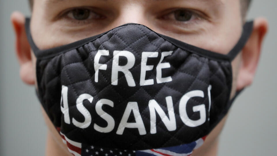 WA 42 Londýn - Demonštrant s ochranným rúškom a nápisom Osloboďte Assangea stojí pred budovou súdu v Londýne v pondelok 7. septembra 2020. V britskej metropole sa začala záverečná fáza procesu vydania zakladateľa platformy WikiLeaks Juliana Assangea do Spojených štátov.
