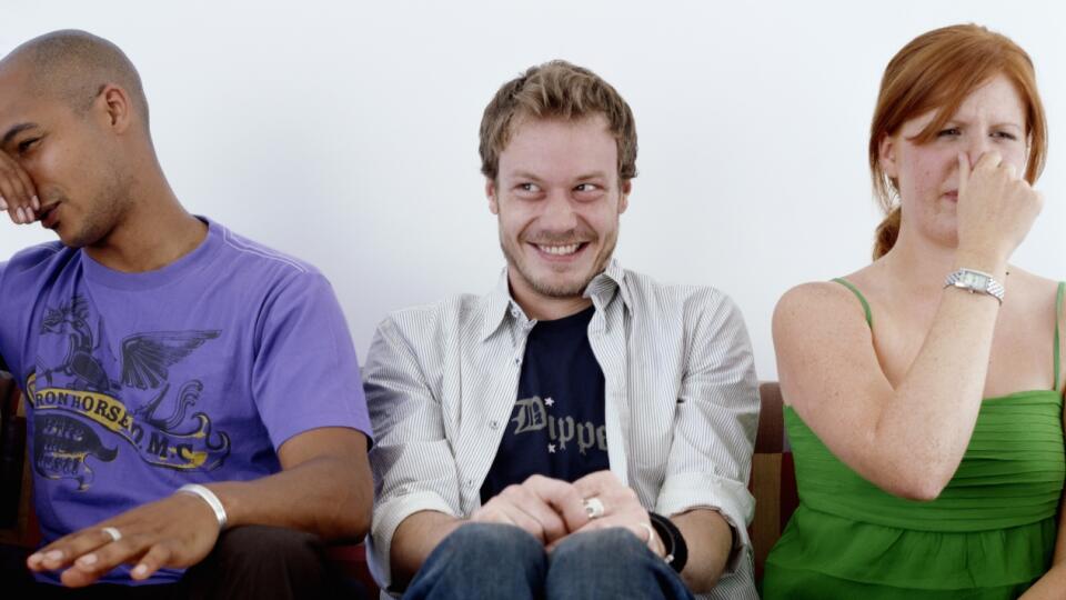 Young man, smiling, sitting between man and woman holding noses 25-29 Years, 30-34 Years, Adults Only, Caucasian Ethnicity, Color Image, Fart, Group Of People, Hair Back, Holding Nose, Horizontal, Humor, In A Row, Indoors, Living Room, Looking Away, Mid Adult Men, Mischief, People, Photography, Redhead, Series, Shaved Head, Short Hair, Sitting, Smiling, Sofa, Three People, Three Quarter Length, Unpleasant Smell, Young Men, Young Women  