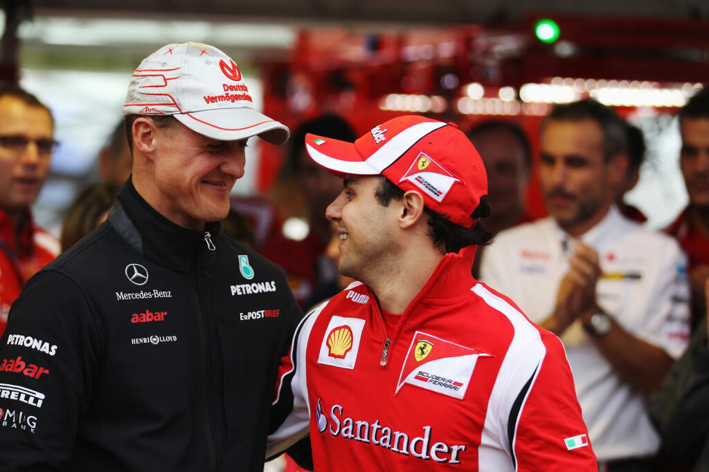 SAO PAULO, BRAZIL - NOVEMBER 26: Felipe Massa (R) of Brazil and Ferrari is seen with former team mate Michael Schumacher of Germany and Mercedes GP as he celebrates 10 years in F1 and 100 races for Ferrari following qualifying for the Brazilian Formula One Grand Prix at the Autodromo Jose Carlos Pace on November 26, 2011 in Sao Paulo, Brazil. (Photo by Mark Thompson/Getty Images)